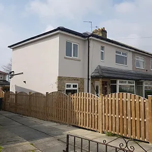 a house with a wooden fence in front of it