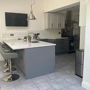 a kitchen with a bar and a television mounted to the wall