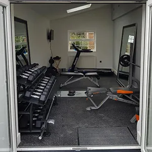 a gym with a treadmill and a mirror