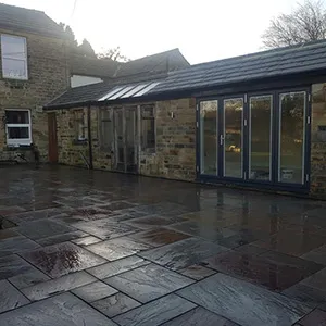 a brick building with a patio and a glass door