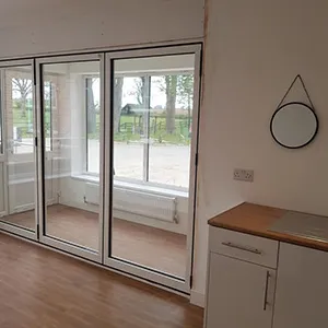 a room with a lot of glass doors and a hard wood floor