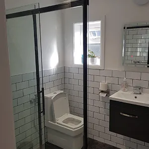 a bathroom with a toilet, sink, and shower stall