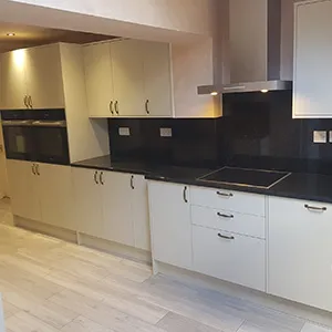 a kitchen with white cabinets and black counter tops